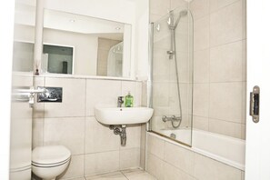 A bathroom with a toilet, sink, and shower. - Cozy Croydon Apartment Retreat (Croydon)