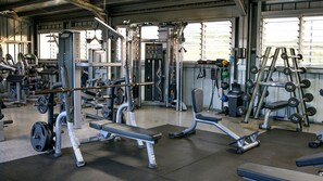 Una palestra con diverse attrezzature per esercizi, tra cui macchinari per pesi e pesi liberi.