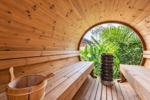 A wooden sauna with benches and a bucket, surrounded by greenery. - Casa Uribe 1972 Art Villa Pool Sauna Ofuro Poblado (Medellín)