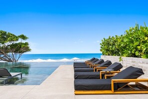 A poolside area with lounge chairs and a view of the ocean. - Naya 6201 Tower VI in Punta de Mita (Punta de Mita)