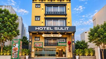 Um hotel chamado 'Hotel Sulit' com fachada moderna, amplas janelas e uma placa indicando South Flavours Junction.