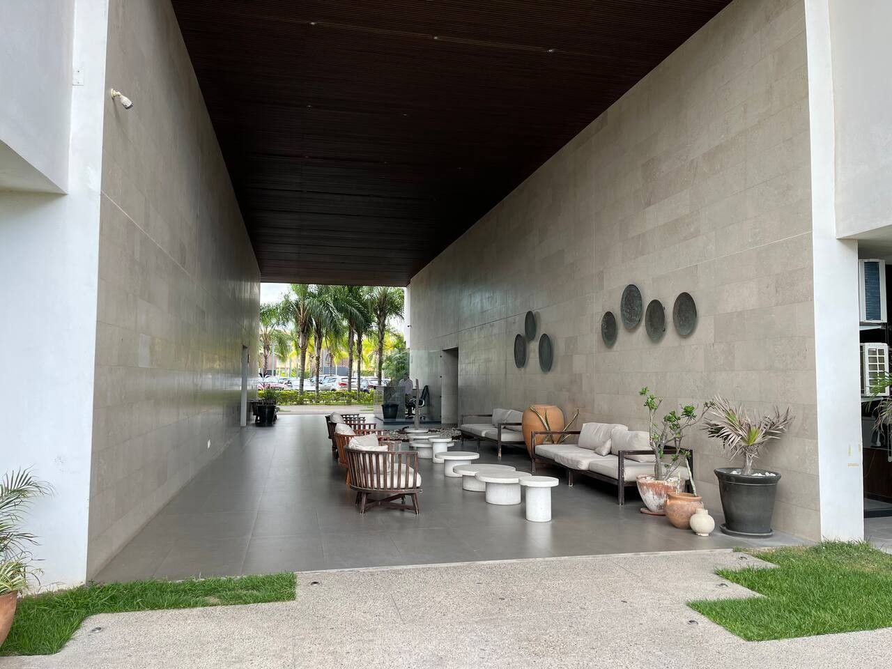 An outdoor seating area with sofas, chairs, and planters.