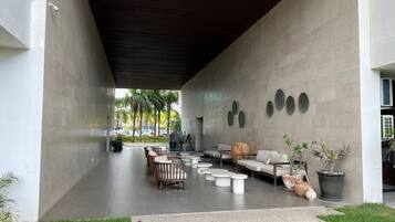 An outdoor seating area with sofas, chairs, and planters.