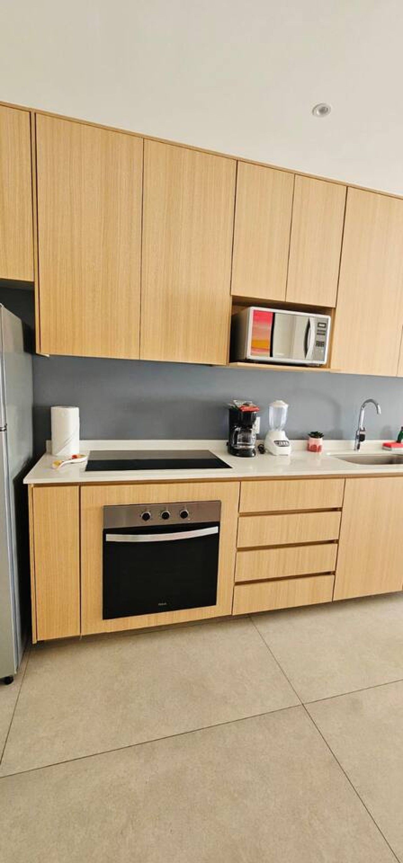 A modern kitchen with wooden cabinets, a built-in microwave, a stove, and a dishwasher.