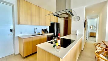 A modern kitchen with wooden cabinets, a central island, and a dining area with chairs.