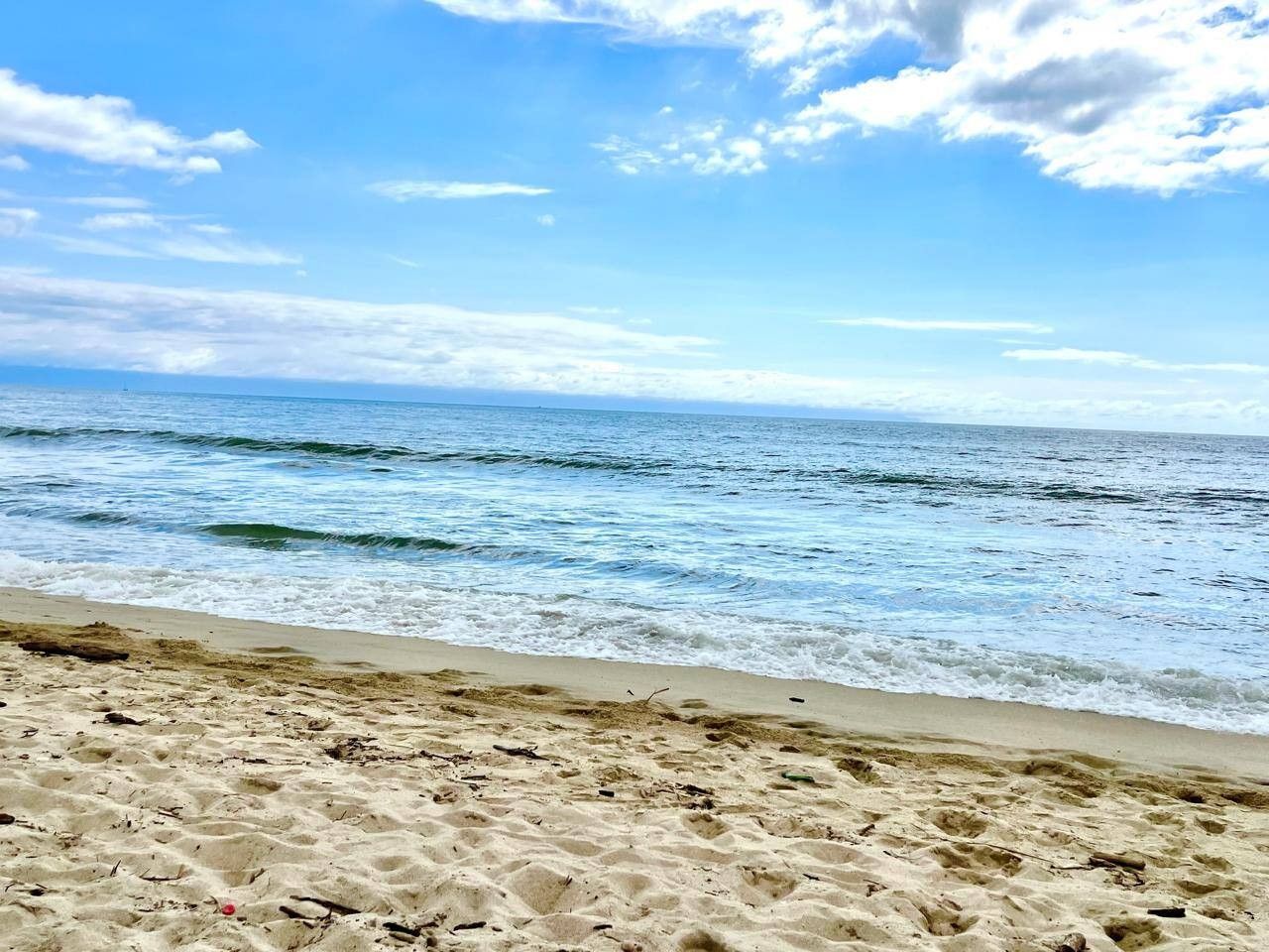 A beach with sand and waves.