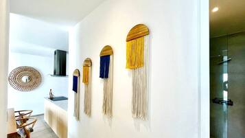 A modern interior with a kitchen area, a dining table, and a wall-mounted decorative piece.