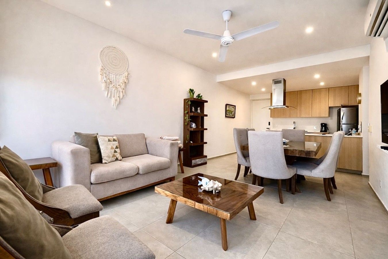 A modern living room with a sofa, coffee table, and dining area.