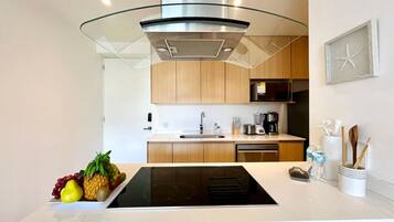 A modern kitchen with a central island, stainless steel appliances, and wooden cabinetry.