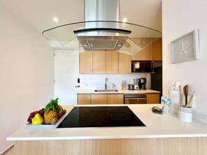Una cucina moderna con isola centrale, elettrodomestici in acciaio inossidabile e mobili in legno.