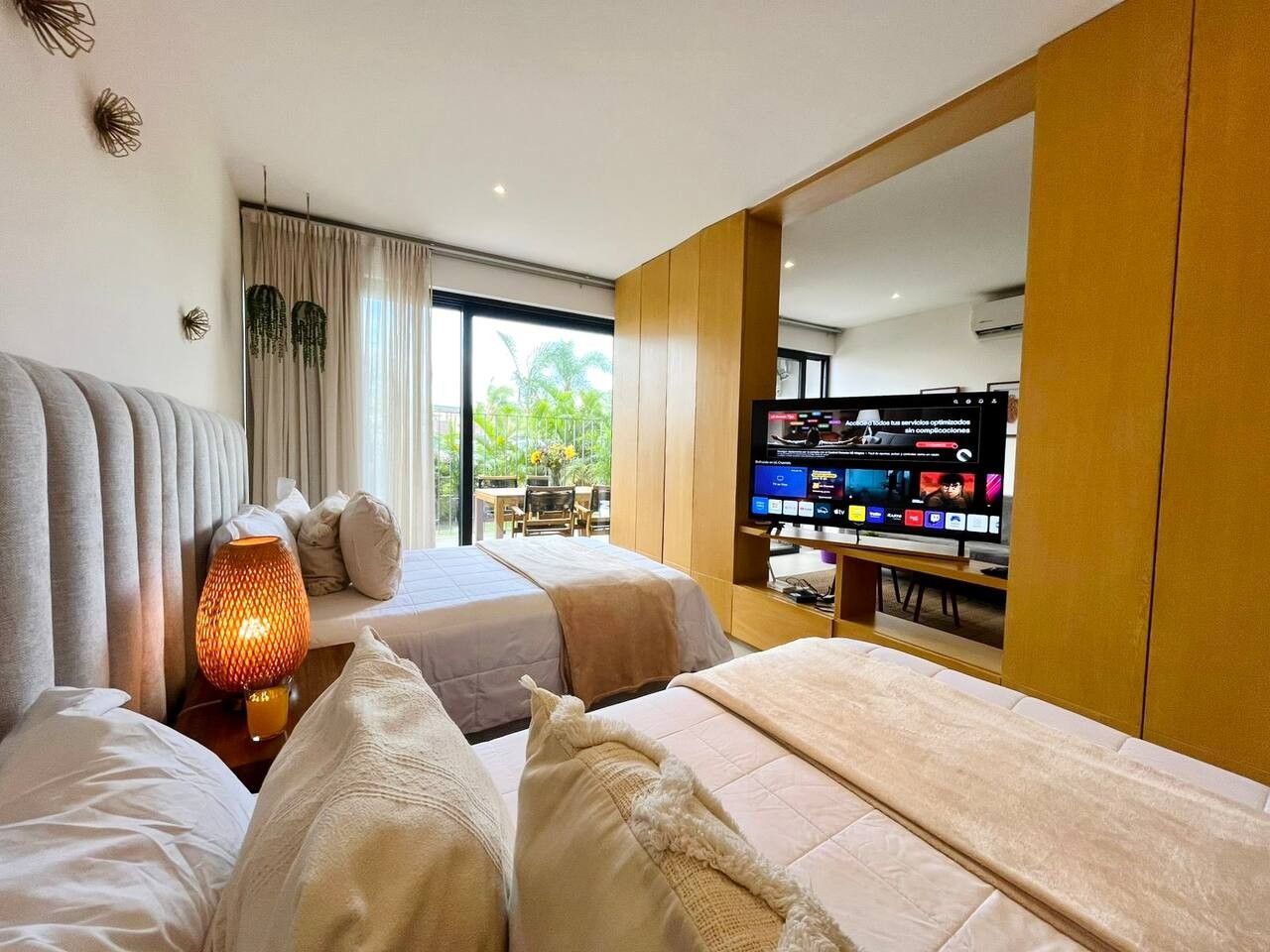 Een hotelkamer met twee bedden, een televisie en een zithoek met een tafel en stoelen.