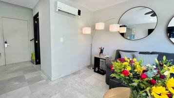 Ein modernes Wohnzimmer mit einer Couch, einem Couchtisch und einer Blumenvase.