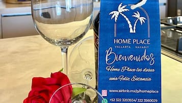 A bottle of wine, a glass, and a blue box with text and a rose.