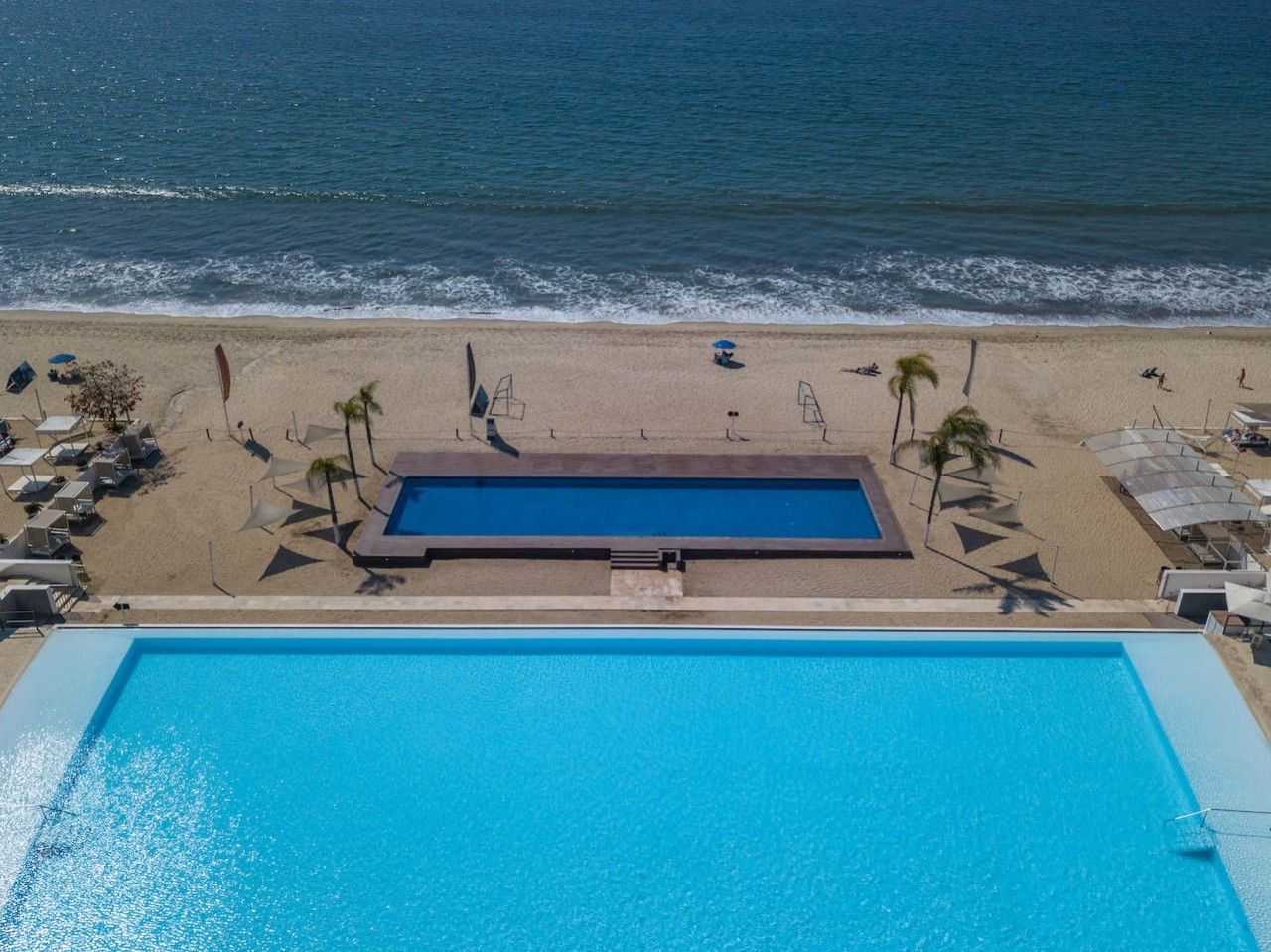 A swimming pool with a view of the beach and ocean.