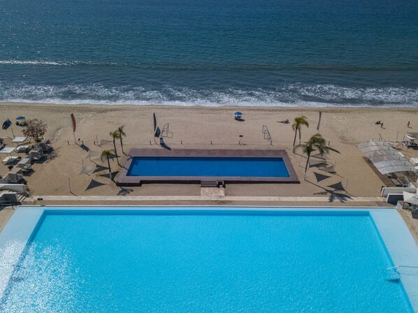 Una piscina con vistas a la playa y al océano.
