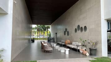 Área externa com mobiliário moderno e plantas em vasos.