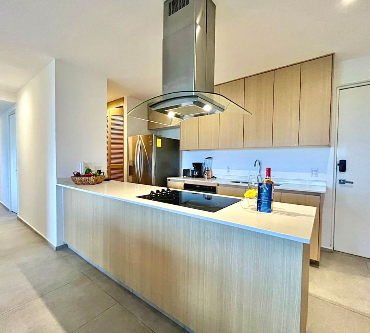 Una cocina moderna con una isla central, electrodomésticos de acero inoxidable y armarios de madera.
