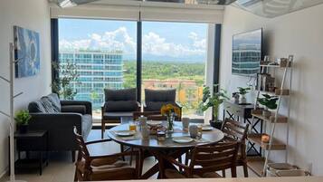 Une cuisine moderne dotée d’un îlot central, d’un coin repas et offrant une vue sur le paysage urbain.