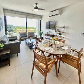 A modern dining area with a round table, chairs, and a breakfast setting. - 8th-Floor Condo with Mountain View & Beach (Nuevo Vallarta)