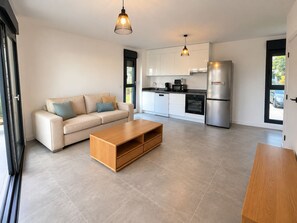 A modern kitchen with white cabinets, a stainless steel refrigerator, and a built-in dishwasher. - Evana · Terrace with bay view · Parking · Air conditioning (Fort-de-France)