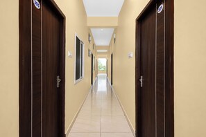 A corridor with doors numbered 305 and 301, leading to a bright interior space.
