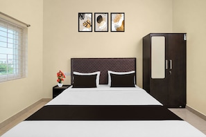 A hotel room with a bed, a nightstand, a wardrobe, and three framed artworks on the wall. - Super Hotel O Temple Road Vemulavada (Karimnagar)