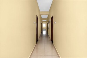 A long, narrow hallway with doors on both sides and a tiled floor.