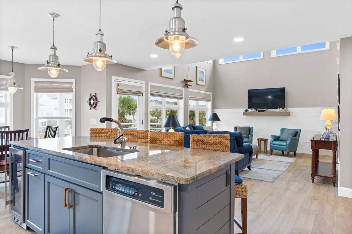 A modern kitchen with a central island, stainless steel appliances, and pendant lighting.