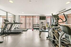 A gym with treadmills, elliptical machines, and free weights. - Bright 2 Bedroom Escape with Stunning City Views (Fortitude Valley)