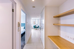 A hotel corridor with a bed, a desk, and a dining area. - 1 Bedroom Cityside Residence (Fortitude Valley)
