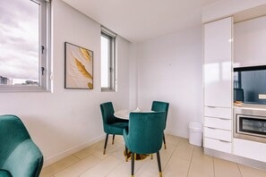 Eine moderne Küche mit weißen Schränken, einem eingebauten Backofen und einem Fenster.