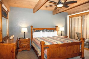 A bedroom with a wooden bed, two bedside tables with lamps, a ceiling fan, and a large window with blinds. - Sedona Oak Creek Villa -w/ AC & Heat (Sedona)