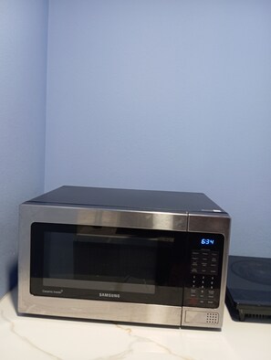 A Samsung microwave oven with a digital display, control panel, and a ceramic interior.