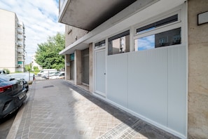 A residential building with a gated entrance, a tiled driveway, and parked cars. - GuestReady - Independent studio near Retiro (Madrid)
