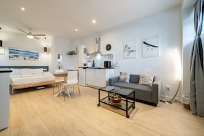 A modern living room with a bed, a sofa, a dining table, and a kitchen area. - GuestReady - Independent studio near Retiro (Madrid)