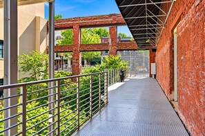 Covered steel walkway framed by century-old brick arches at The Emporium, a downtown Knoxville vacation rental steps from Old City restaurants and a 10-minute walk to Market Square. - Street View Condo | Walk to Knoxville’s Best (Knoxville)