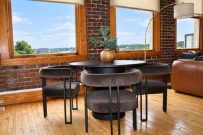 Un intérieur moderne avec une table ronde, quatre chaises, un vase et un canapé.