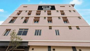 A hotel building with a sign indicating it is 'Hotel OWO-Serviced.'