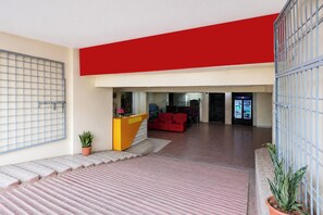 Un intérieur moderne avec un comptoir d’accueil, un canapé rouge et un distributeur automatique.
