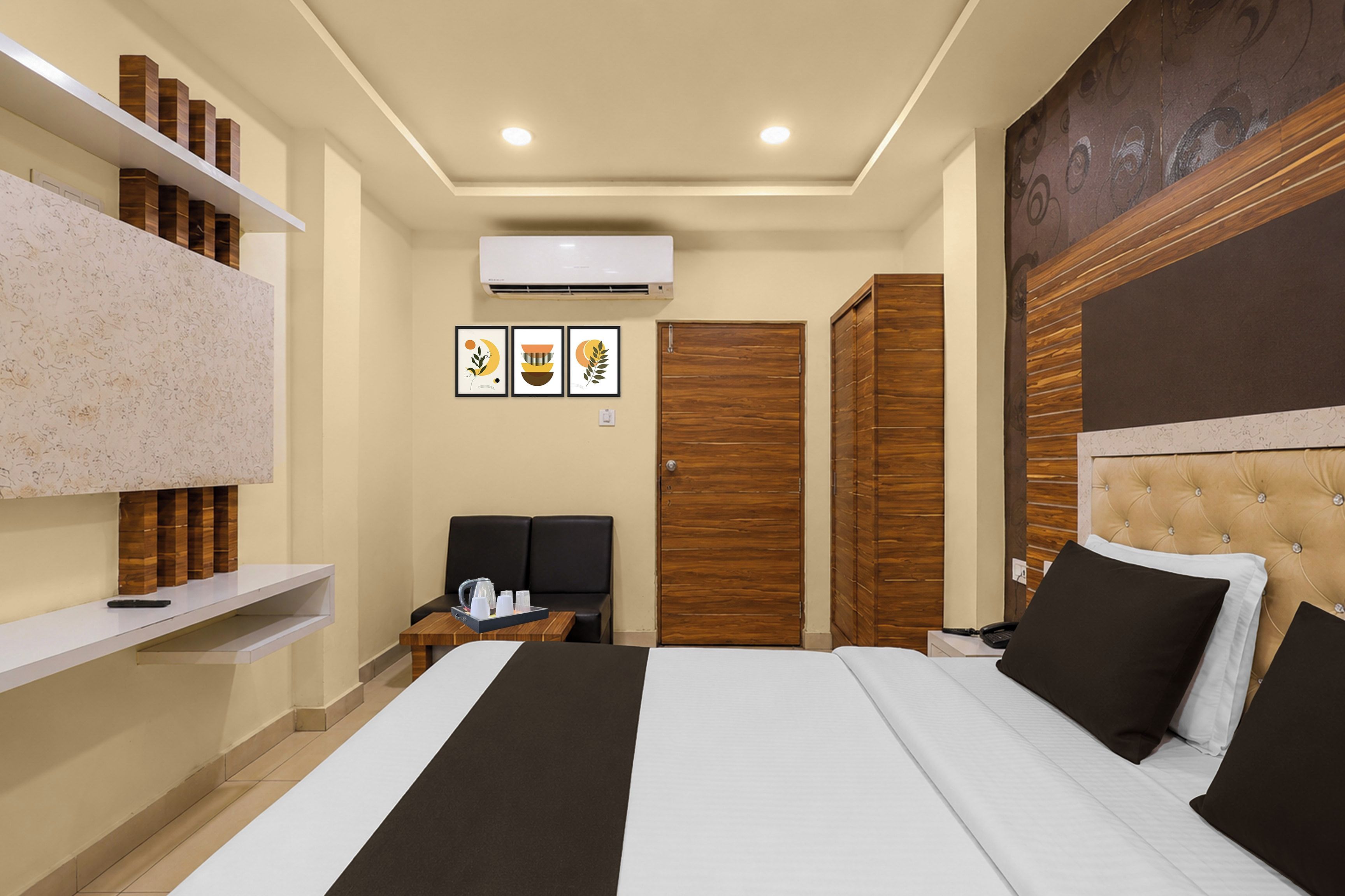 Habitación de hotel con una cama, una mesita de noche con teléfono, aire acondicionado instalado en la pared y una puerta con panel de madera.
