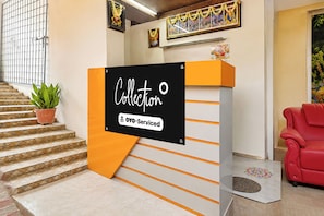 Una mesa de recepción con un letrero que dice 'Colección' y 'OYO-Serviced'.