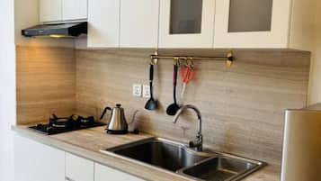 A modern kitchen with a gas stove, stainless steel sink, and wooden countertop.