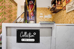 Balcão de recepção com uma placa que diz 'Collection' e 'YO-Serviced'.