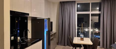 A modern kitchen with a built-in oven and a dining area with a table and chairs.