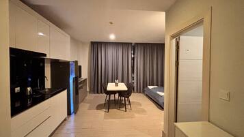 Une chambre d’hôtel compacte comprenant un coin cuisine, un espace repas et un lit.