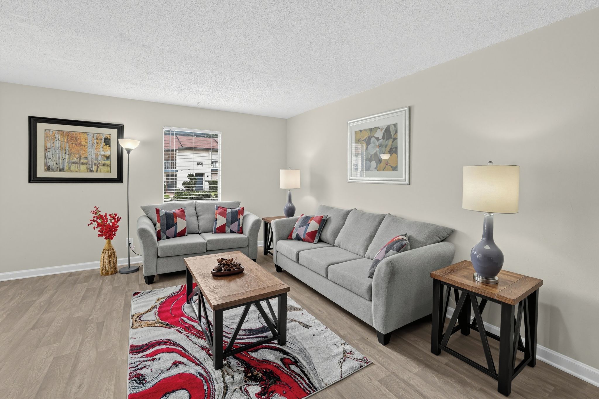 A living room with a grey sofa, a wooden coffee table, and two side tables with lamps.