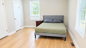 Une chambre à coucher avec un lit, un ventilateur de plafond, une fenêtre et une porte.