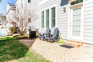 A residential property with a brick patio, outdoor seating, and a barbecue grill. - 4BR, 3.5BA beach retreat in Virginia Beach with parking, patio & kitchen. (Virginia Beach)