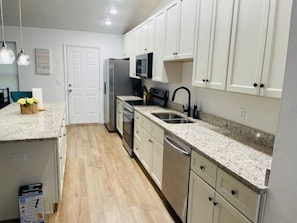 A kitchen with white cabinets, a stainless steel refrigerator, a microwave, and a dishwasher. - [5B/2B]-Spacious 5-bedroom house in quaint Quincy for working crews (Quincy)