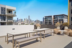 Eine Dachterrasse mit Sitzgelegenheiten und Blick auf die Stadtlandschaft.
